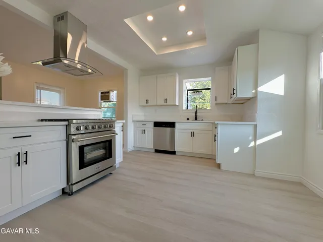 a kitchen with stainless steel appliances granite countertop a stove a sink dishwasher and a refrigerator