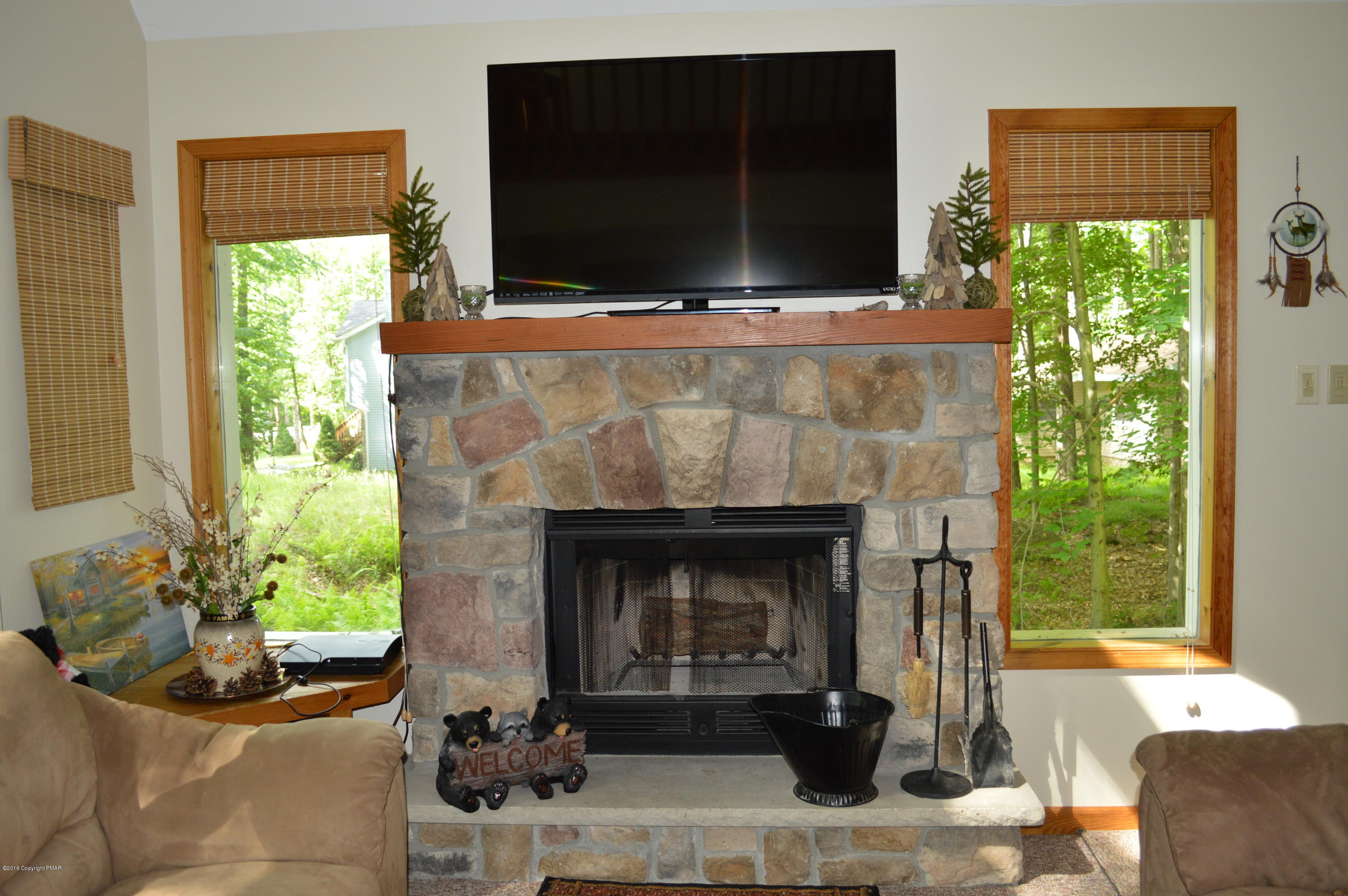 139 Selig Road Pocono Lake, PA 18347 - Photo 5 of 33 a living room with a fireplace and a flat screen tv