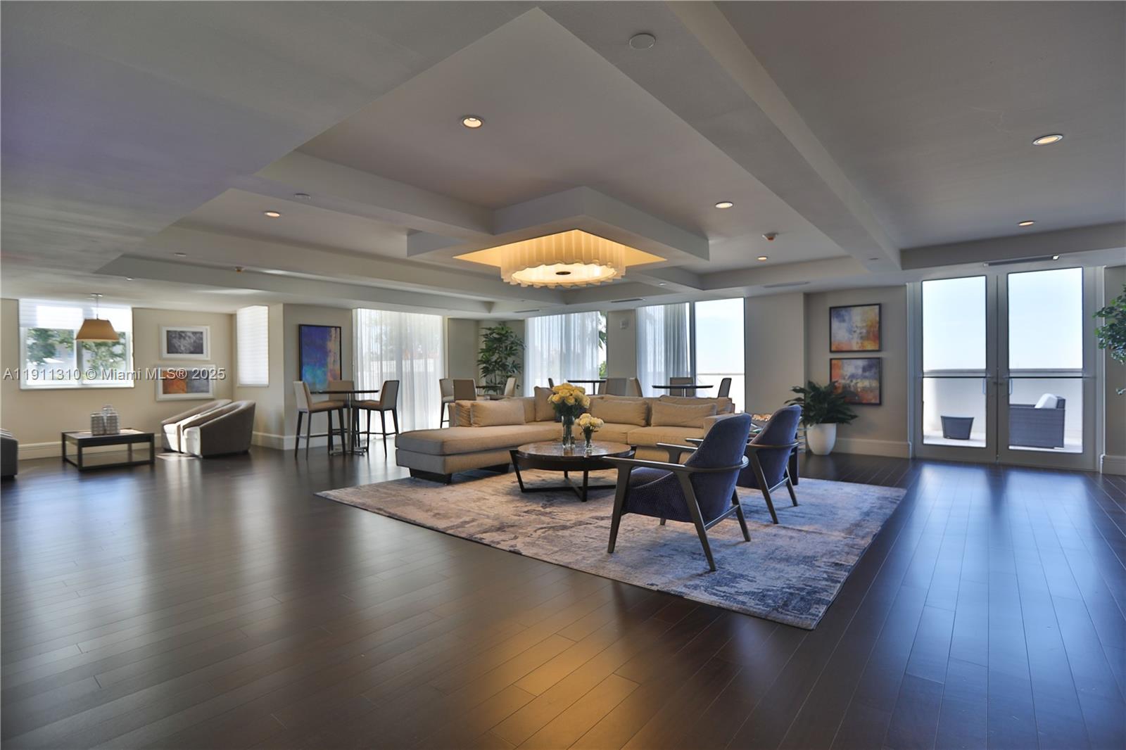 2000 Salzedo Street, Unit 512 Coral Gables, FL 33134 - Photo 16 of 17 a living room with couches and a dining table with wooden floor
