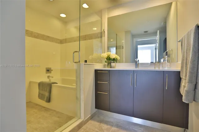 a bathroom with a granite countertop sink a mirror and a shower
