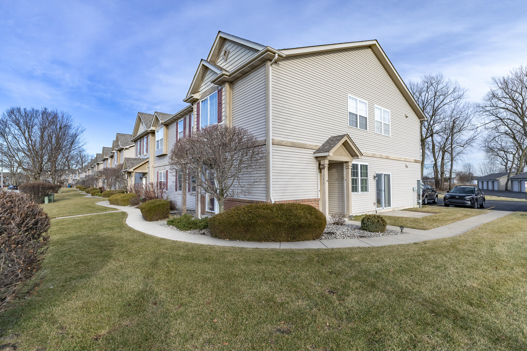 a view of a white house with a small yard and plants