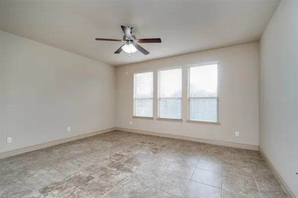 an empty room with closet and a ceiling fan