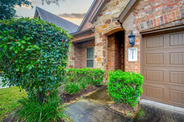 a view of a brick house with a large windows and plants