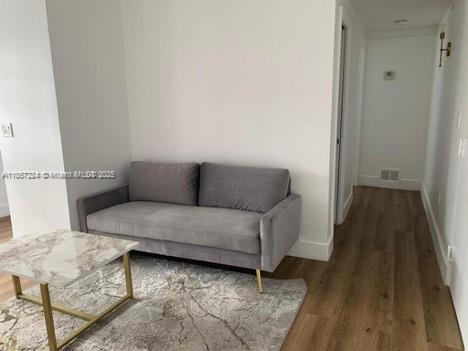 a living room with furniture and a wooden floor
