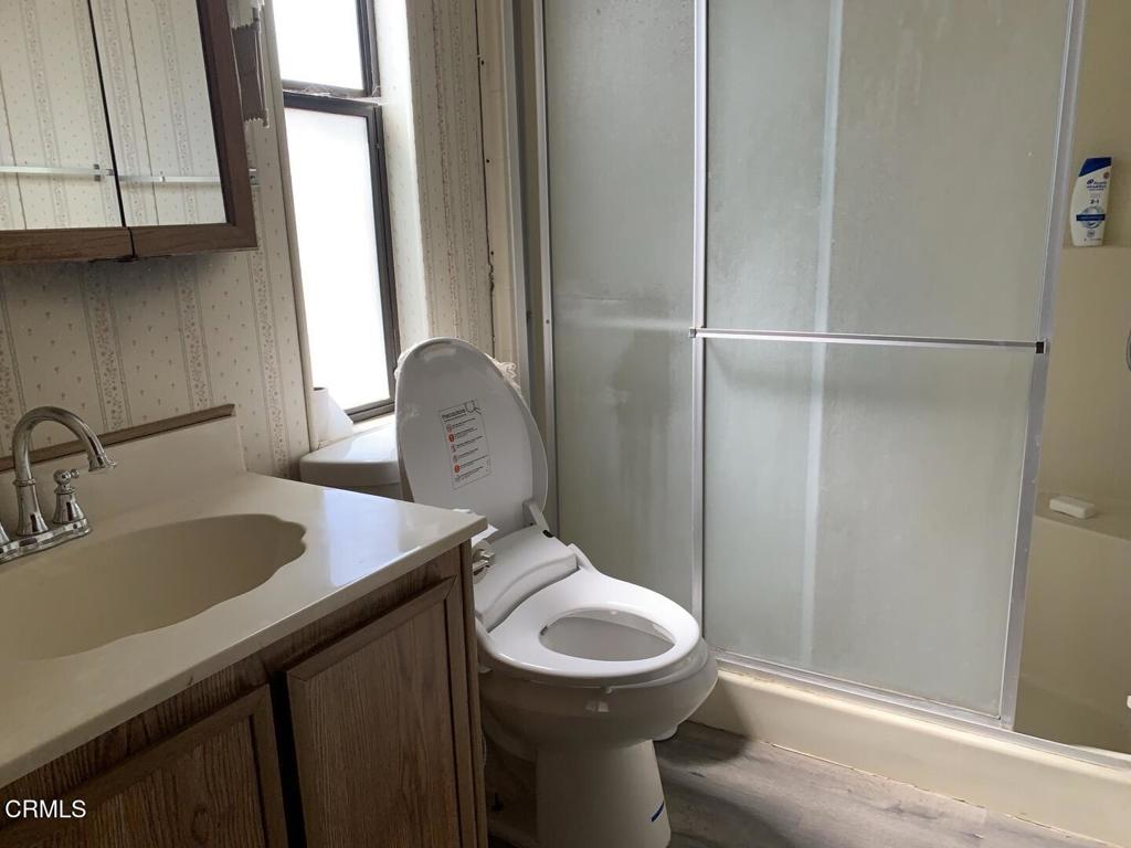 10200 Johnson Road, Unit 52 Phelan, CA 92371 - Photo 2 of 13 a bathroom with a toilet a sink and mirror