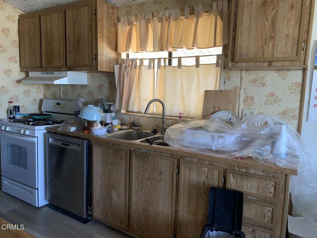 10200 Johnson Road, Unit 52 Phelan, CA 92371 - Photo 6 of 13 a kitchen with granite countertop a stove a sink and a cabinets