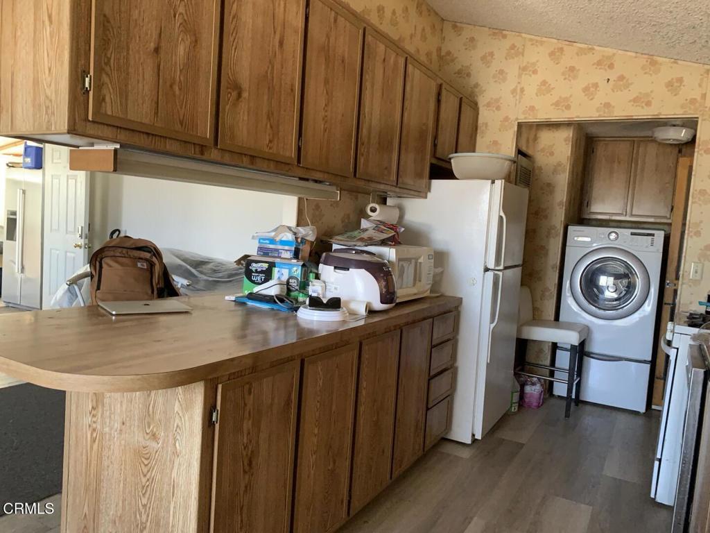 10200 Johnson Road, Unit 52 Phelan, CA 92371 - Photo 7 of 13 a kitchen with stainless steel appliances granite countertop a refrigerator a sink and wooden cabinets