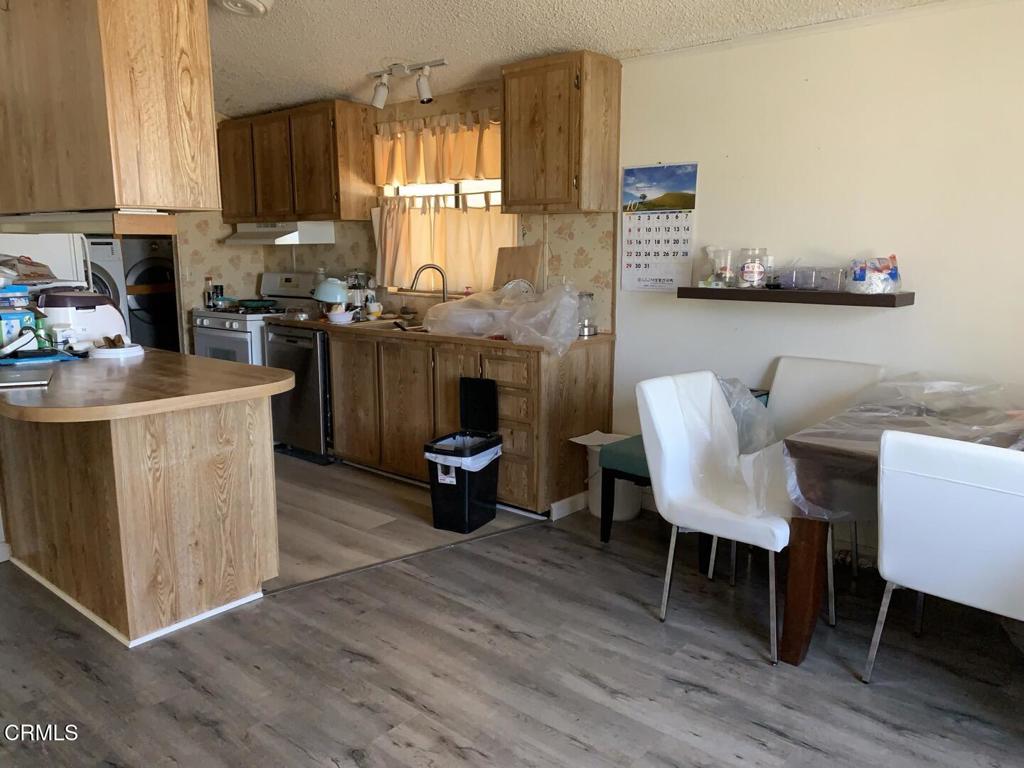 10200 Johnson Road, Unit 52 Phelan, CA 92371 - Photo 9 of 13 a living room with furniture a flat screen tv and kitchen floor