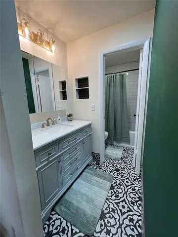 a bathroom with a sink a toilet a mirror and shower