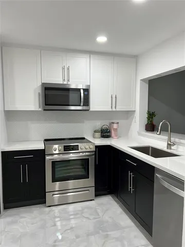 a kitchen with stainless steel appliances granite countertop a stove microwave and sink
