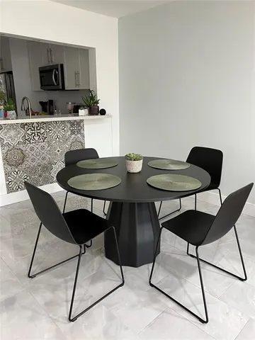 a kitchen with a dining table chairs and white kitchen