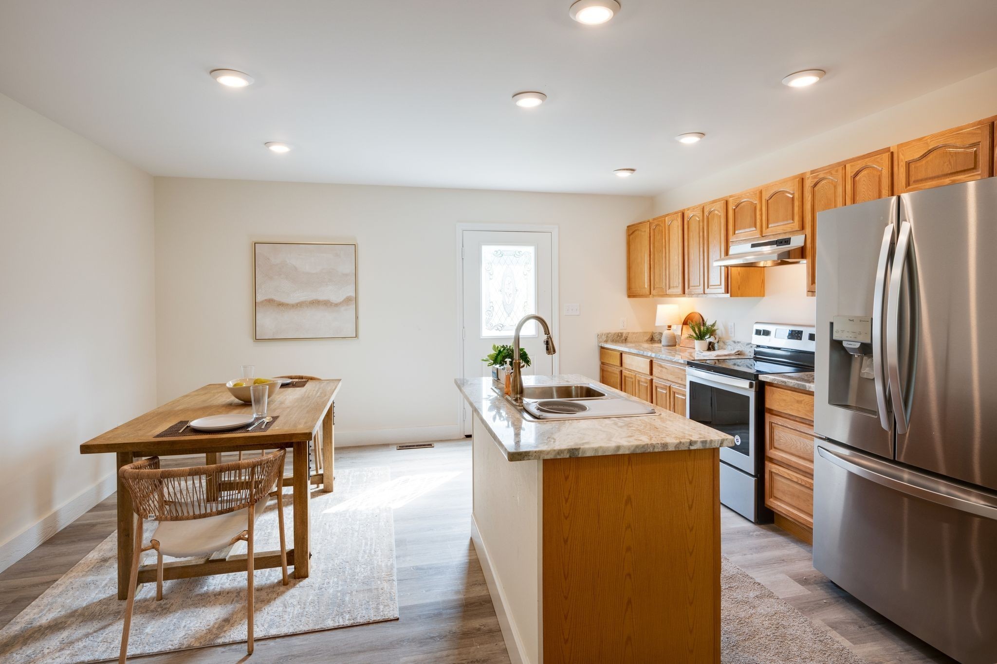 116 Fairground Drive Waverly, TN 37185 - Photo 12 of 30 a kitchen with stainless steel appliances granite countertop a refrigerator a stove a sink a dining table and chairs with wooden floor