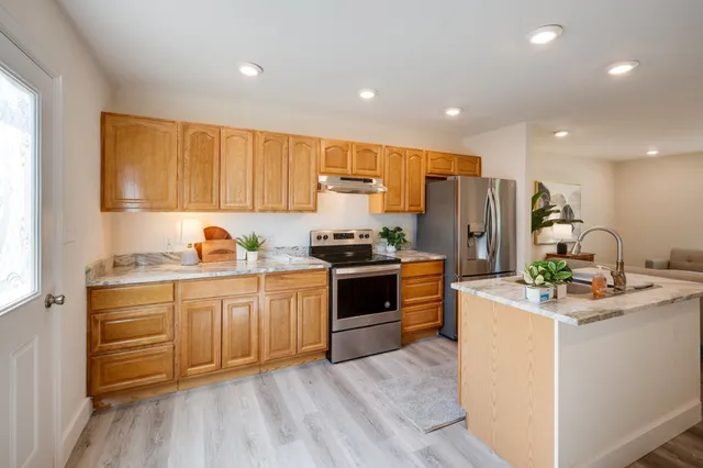a kitchen with stainless steel appliances a refrigerator stove and sink