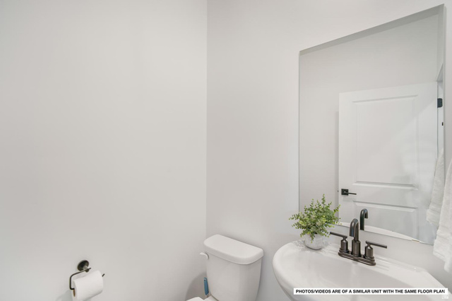 1702 Ripple Rock Drive, Unit 3171 Washington, UT 84780 - Photo 16 of 16 Pedestal sink with dark bronze fixtures and a wall-mounted mirror