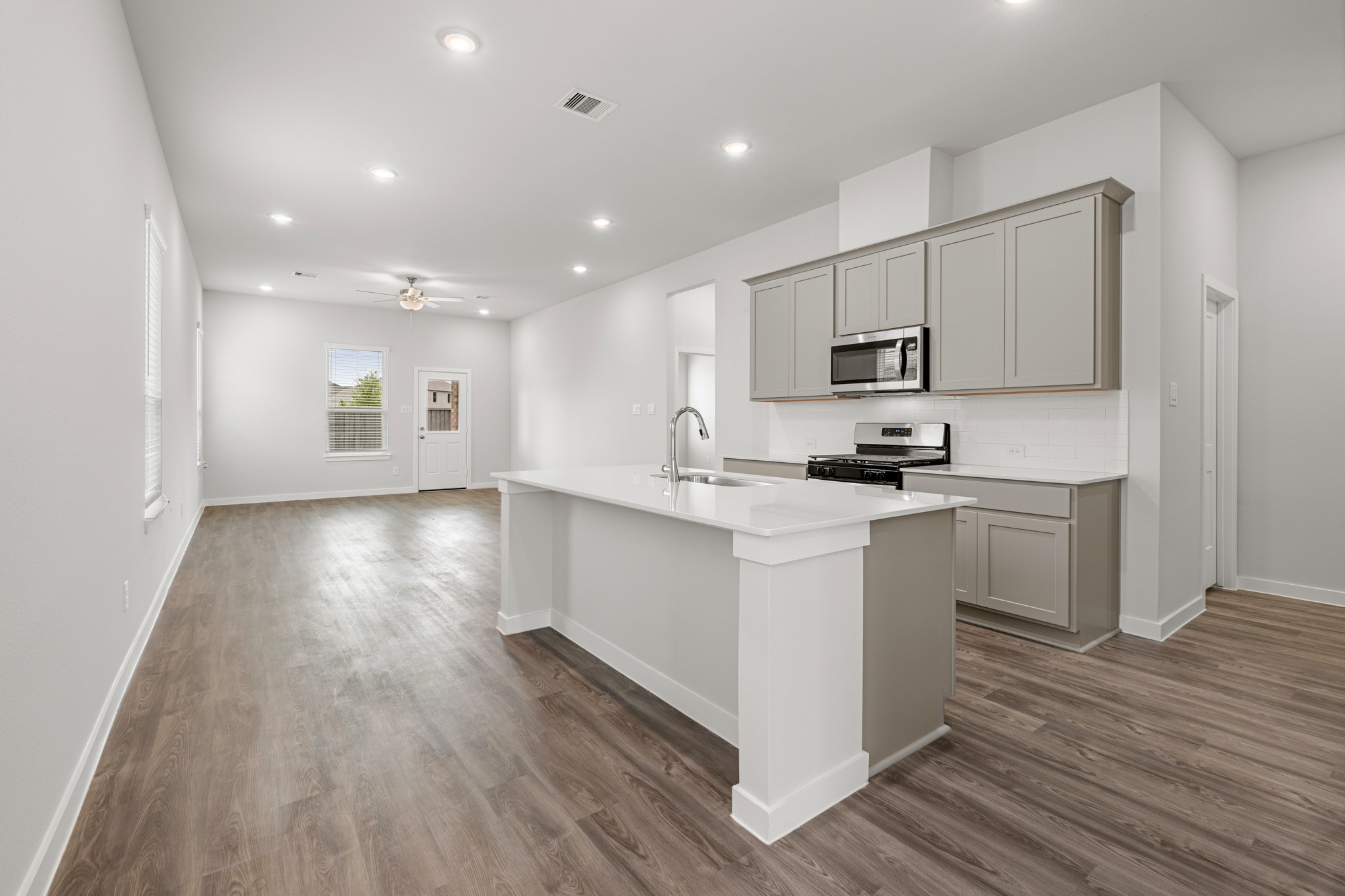 641 Pomegranate Lane La Marque, TX 77568 - Photo 4 of 22 a kitchen with a white wooden floor cabinets and a center island