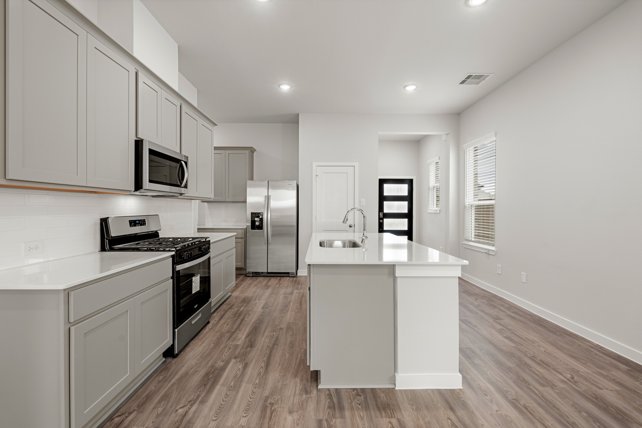 641 Pomegranate Lane La Marque, TX 77568 - Photo 6 of 22 a kitchen with stainless steel appliances a stove top oven a sink a refrigerator white cabinets and wooden floor