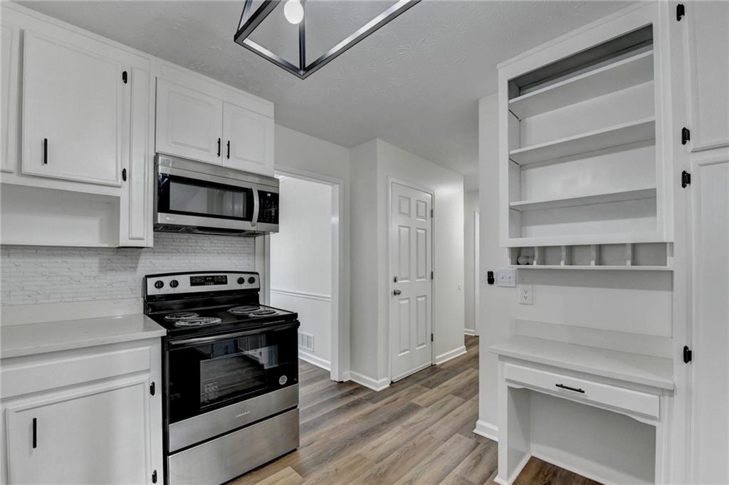 1530 Plunketts Road Buford, GA 30519 - Photo 29 of 54 a kitchen with stainless steel appliances white cabinets and a stove top oven