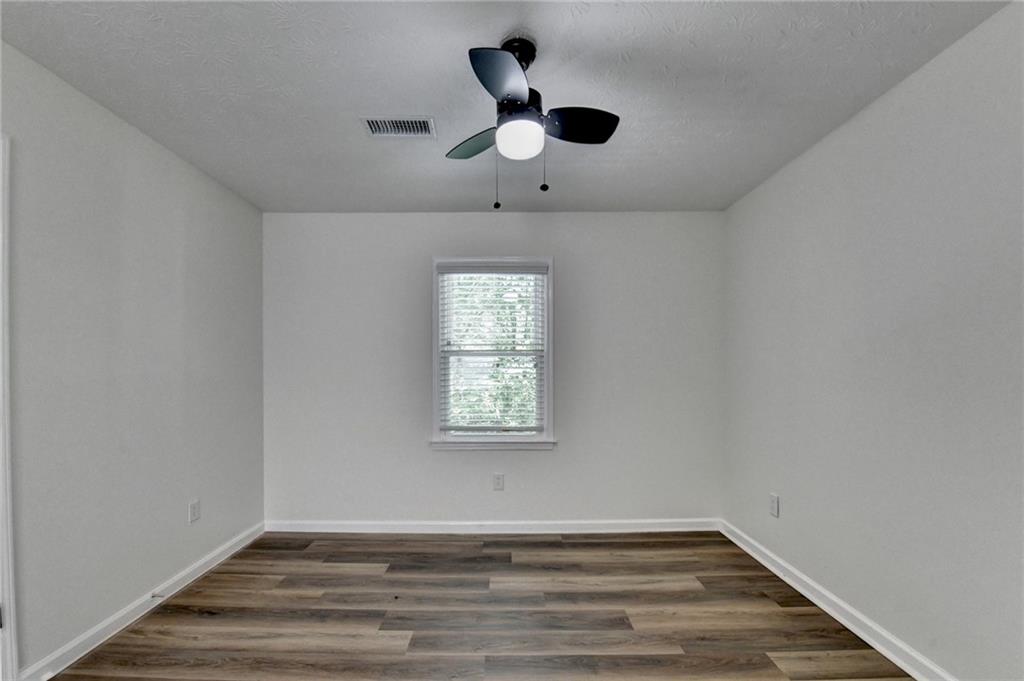 1530 Plunketts Road Buford, GA 30519 - Photo 35 of 54 a view of an empty room with wooden floor and a window