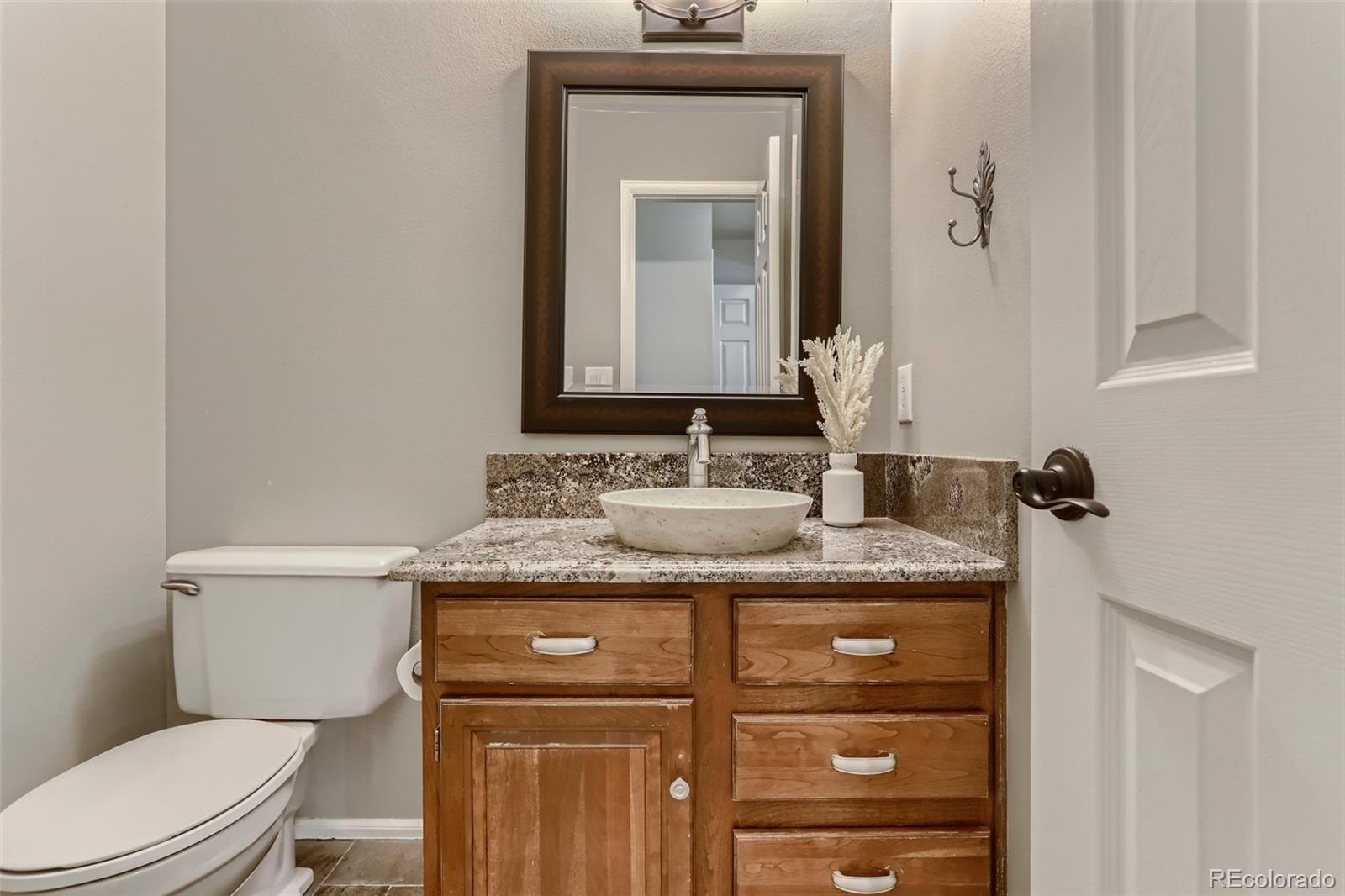 2185 Thistle Ridge Circle Highlands Ranch, CO 80126 - Photo 16 of 37 a bathroom with a granite countertop toilet sink and mirror