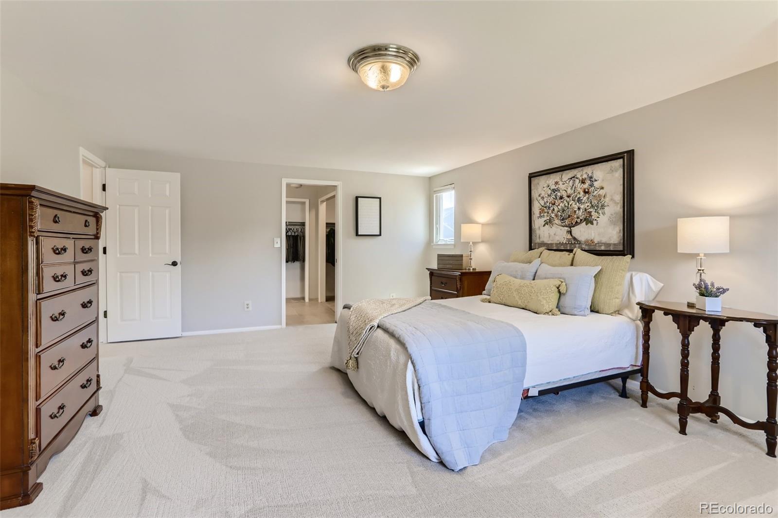 2185 Thistle Ridge Circle Highlands Ranch, CO 80126 - Photo 20 of 37 a spacious bedroom with a bed and cabinet