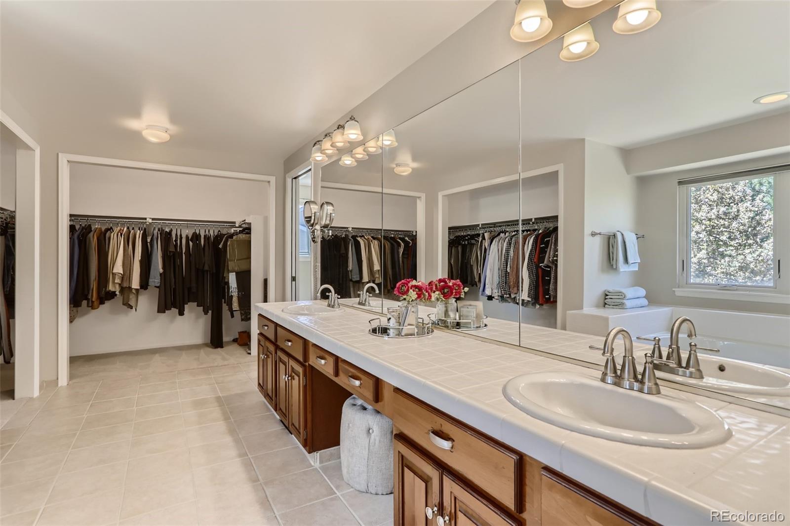 2185 Thistle Ridge Circle Highlands Ranch, CO 80126 - Photo 23 of 37 a bathroom with double vanity sinks a vanity a mirror and shower