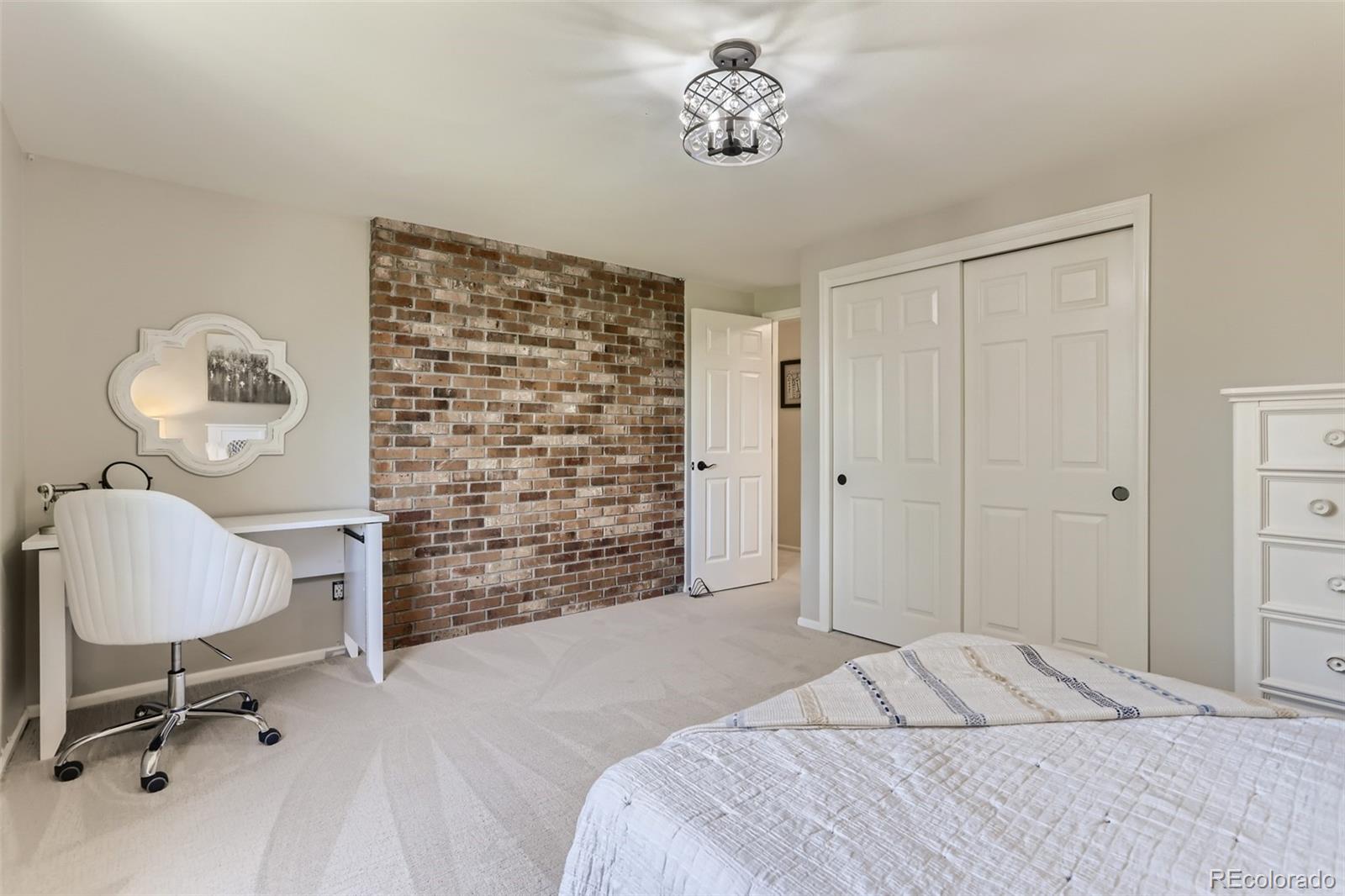 2185 Thistle Ridge Circle Highlands Ranch, CO 80126 - Photo 27 of 37 a bedroom with a bed and a chandelier