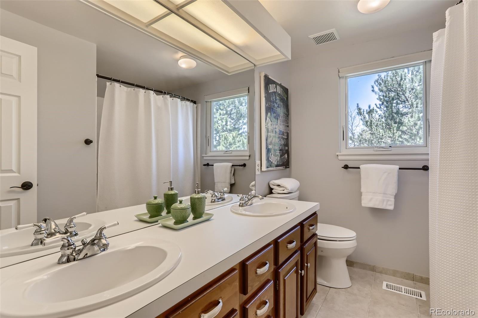 2185 Thistle Ridge Circle Highlands Ranch, CO 80126 - Photo 28 of 37 a bathroom with a double vanity sink toilet and a mirror