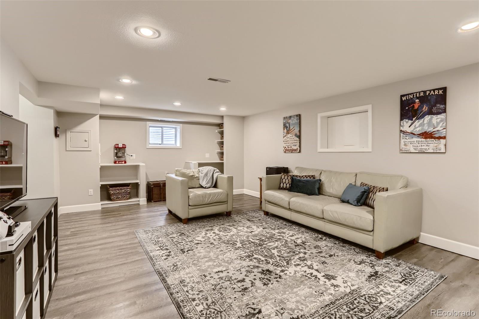 2185 Thistle Ridge Circle Highlands Ranch, CO 80126 - Photo 30 of 37 a living room with furniture a fireplace and a flat screen tv