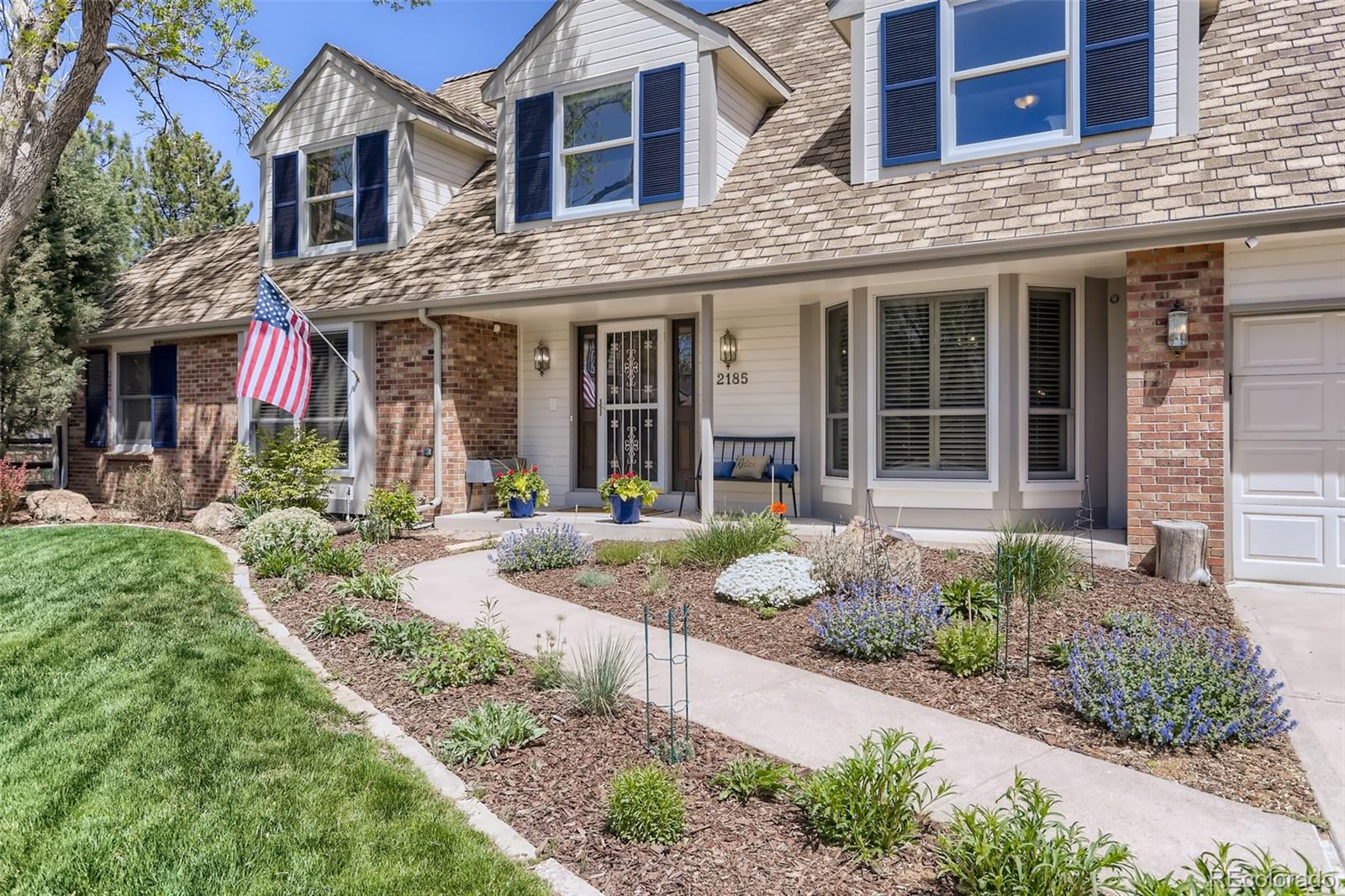 2185 Thistle Ridge Circle Highlands Ranch, CO 80126 - Photo 3 of 37 a front view of a house with garden and porch