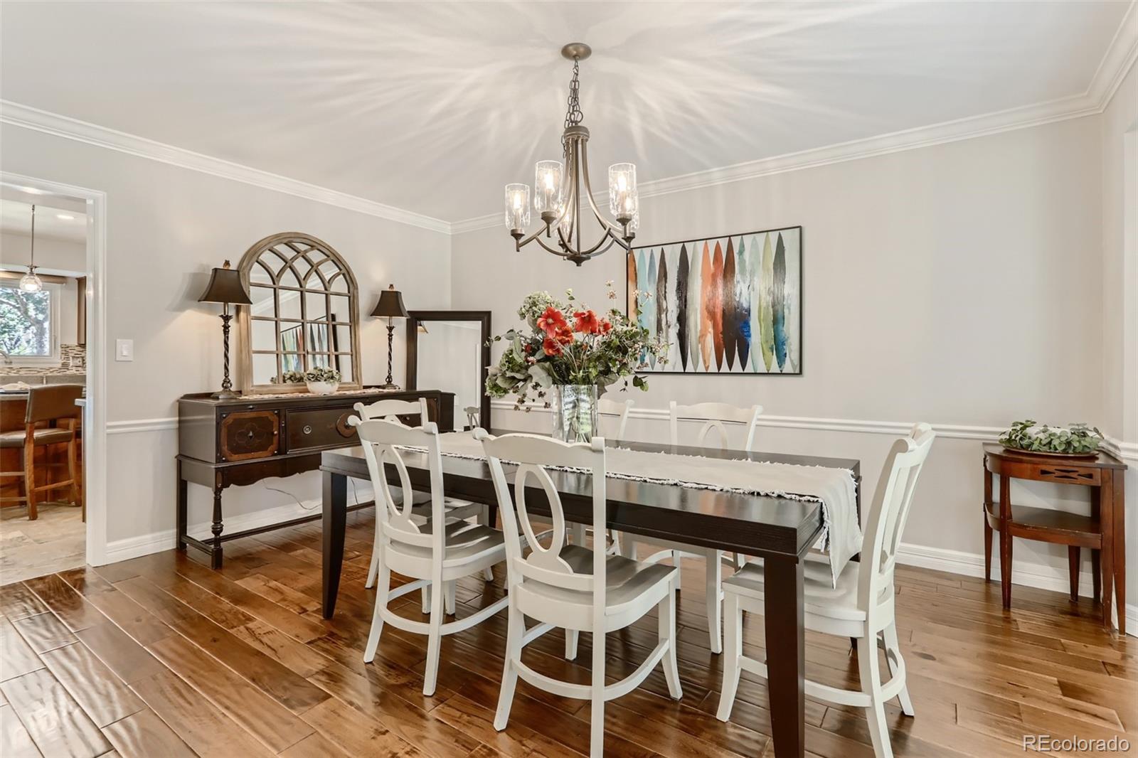 2185 Thistle Ridge Circle Highlands Ranch, CO 80126 - Photo 8 of 37 a view of a dining room with furniture a chandelier and wooden floor