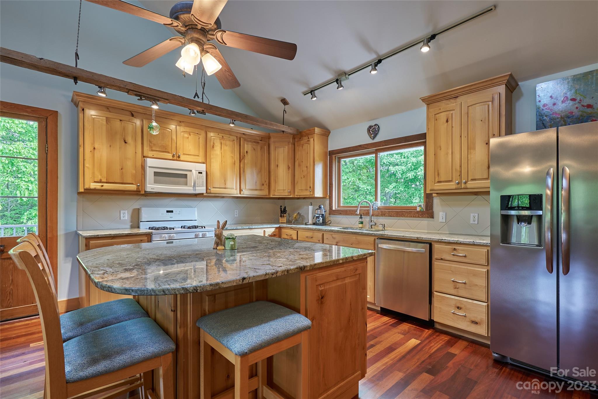 204 Hooker Road Tryon, NC 28782 - Photo 15 of 34 a kitchen with stainless steel appliances granite countertop a table chairs sink refrigerator and cabinets