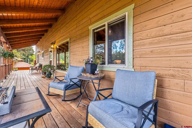 a view of a patio with table and chairs with wooden floor and fence