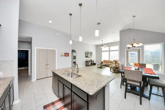 a living room with furniture a flat screen tv and kitchen view
