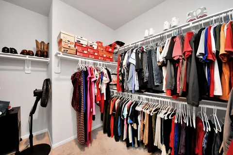 a view of walk in closet with clothes