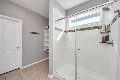 a bathroom with a shower and a glass door