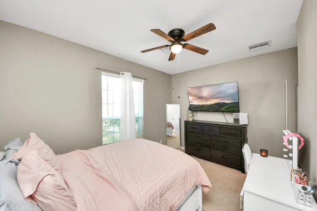 a bedroom with a large bed and a chandelier