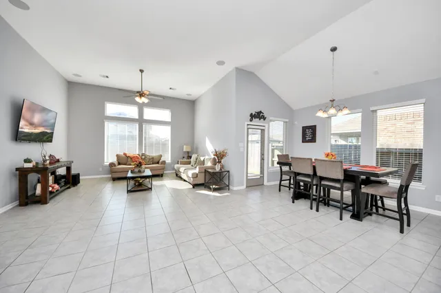 a living room with furniture a flat screen tv and a large window