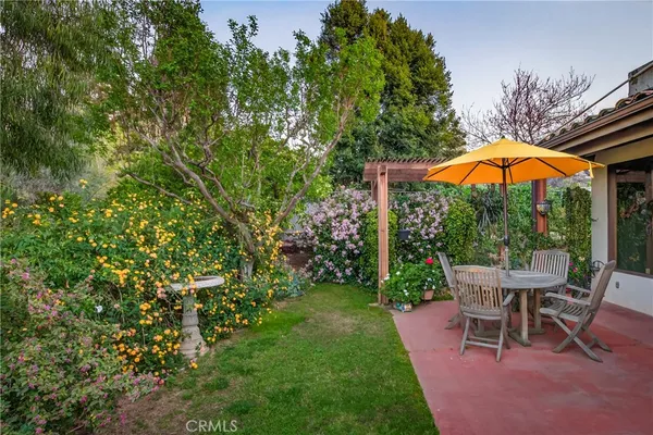 a room with stainless steel appliances kitchen island granite countertop a table chairs in it and a wooden floor
