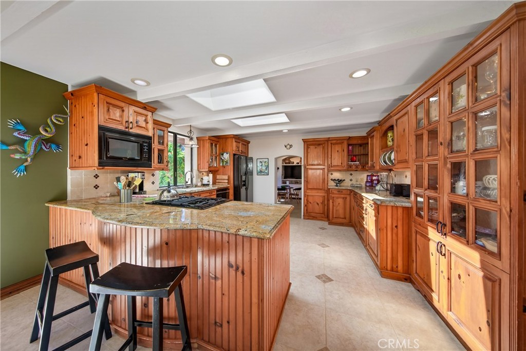 707 Wabash Avenue Redlands, CA 92374 - Photo 15 of 50 a room with stainless steel appliances kitchen island granite countertop a table chairs in it and a wooden floor