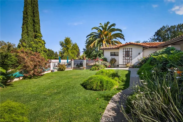 a view of a house with a yard and potted plants