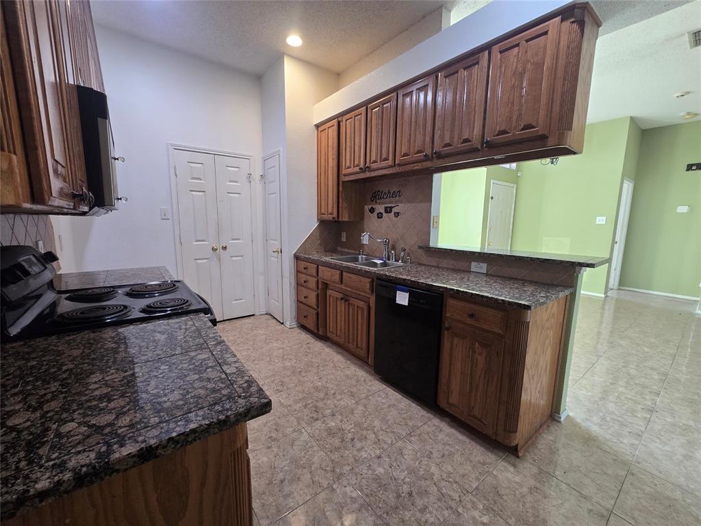 8012 Ashridge Road Fort Worth, TX 76134 - Photo 13 of 18 a kitchen with stainless steel appliances granite countertop a stove a sink and a microwave