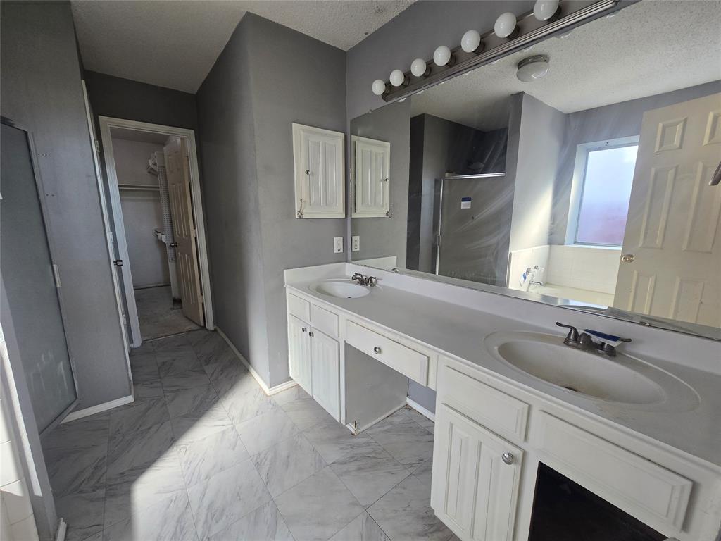 8012 Ashridge Road Fort Worth, TX 76134 - Photo 6 of 18 a spacious bathroom with a double vanity sink a mirror and shower