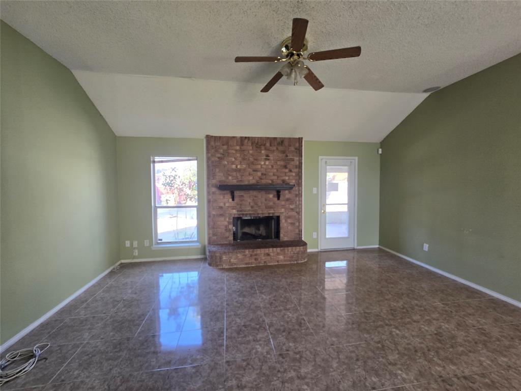 8012 Ashridge Road Fort Worth, TX 76134 - Photo 9 of 18 a view of an empty room with a fireplace and a window