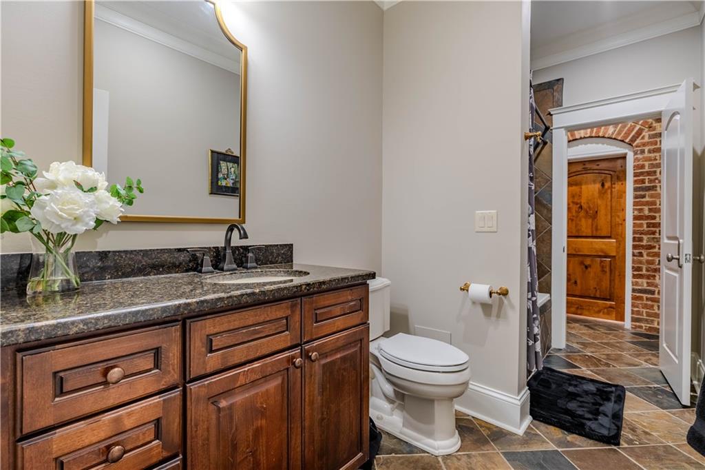 525 North River Road Northeast Rome, GA 30161 - Photo 60 of 101 a bathroom with a granite countertop toilet a sink and a mirror