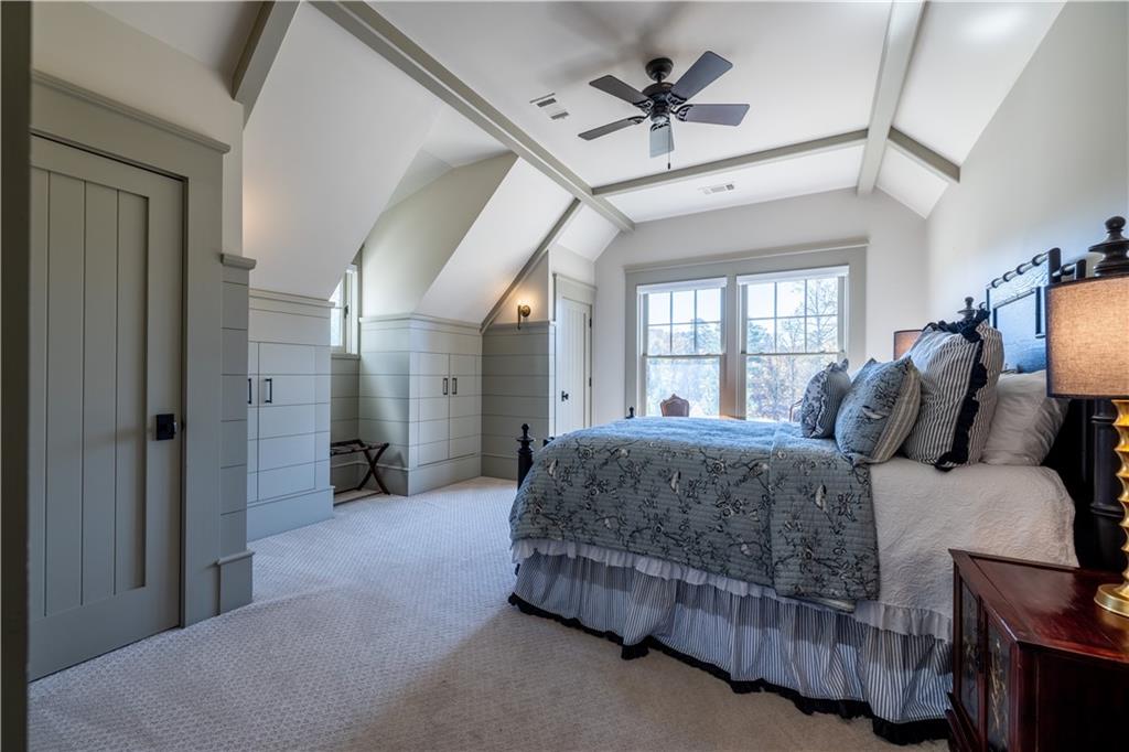 525 North River Road Northeast Rome, GA 30161 - Photo 92 of 101 a spacious bedroom with a bed a chandelier and large window