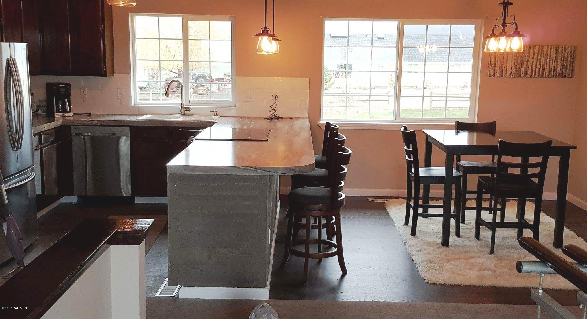 135 Slavin Heights Road Yakima, WA 98903 - Photo 11 of 25 a kitchen with stainless steel appliances granite countertop a stove a sink a dining table and chairs
