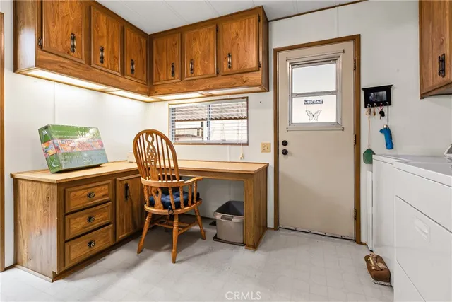 a living room with stainless steel appliances furniture a flat screen tv and a refrigerator