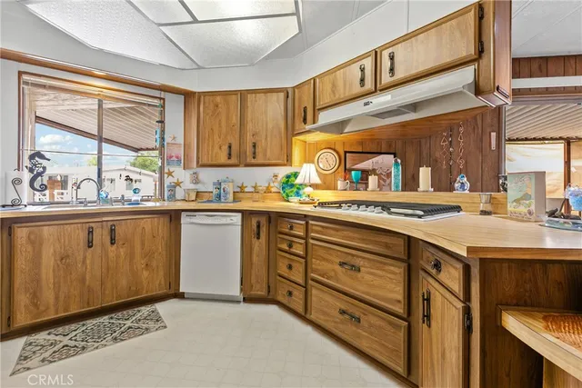 a kitchen with a sink a stove cabinets and a dining table