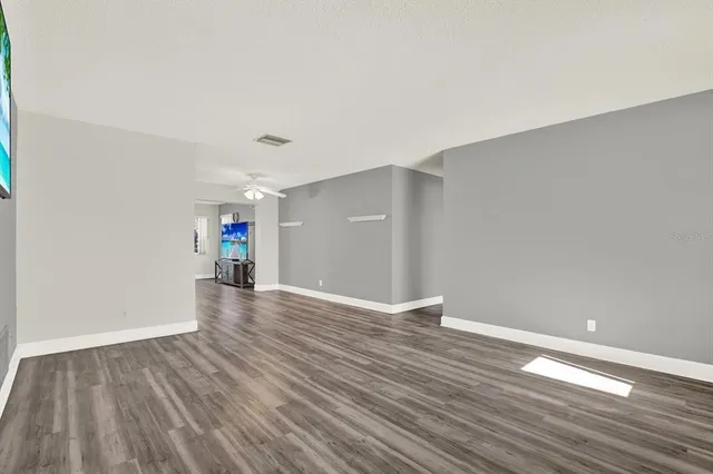 a view of empty room with wooden floor