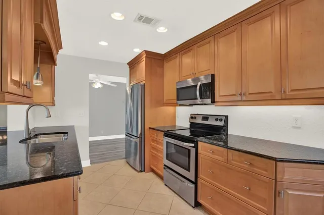 a kitchen with stainless steel appliances granite countertop a refrigerator and a sink
